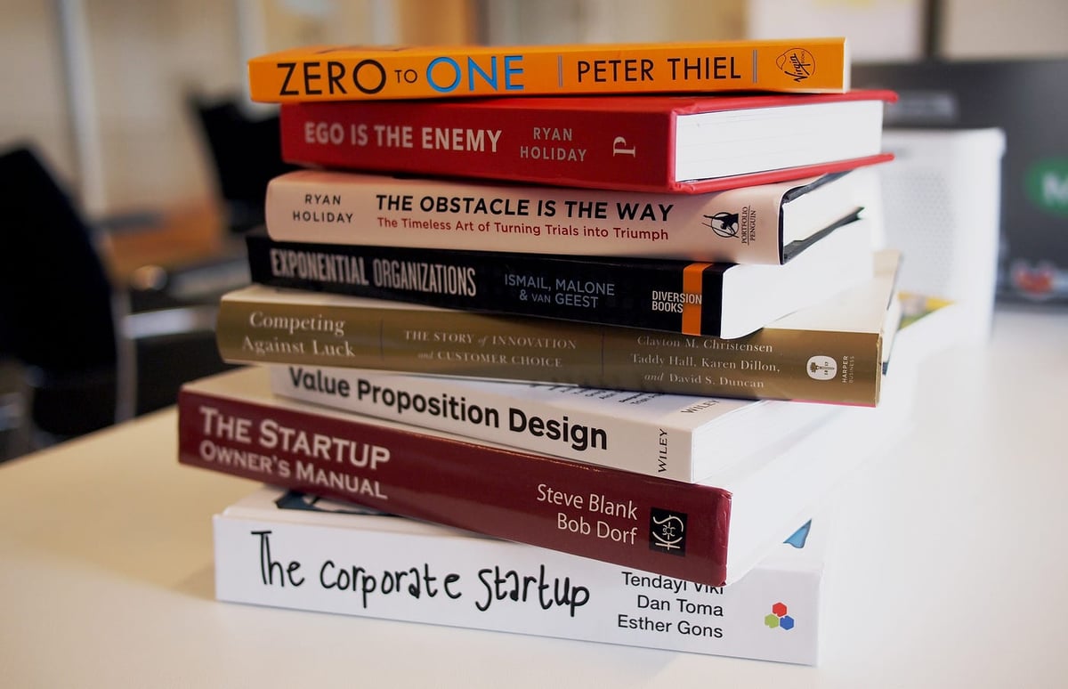 Stack of design books including ego is the enemy